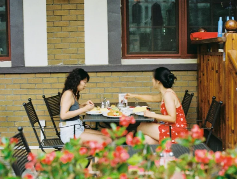 A sunny patio dining table with summer dishes like grilled salmon, salad, and lemonade