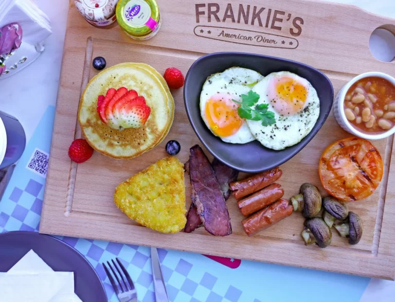 Best brunch menus to try in America - Classic American brunch spread with pancakes, eggs, bacon, and fresh fruit on a wooden table