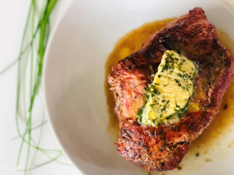Best steakhouse menu items in America - A perfectly cooked steak with butter and herbs on a plate