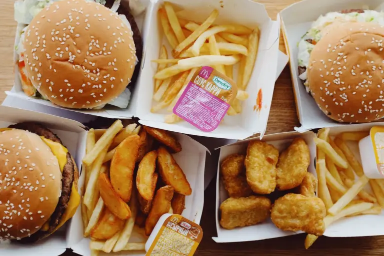 Best burger chain menu items in America - Collage of best burgers from Shake Shack, In-N-Out, Wendy's, Chick-fil-A, and Five Guys on wooden
