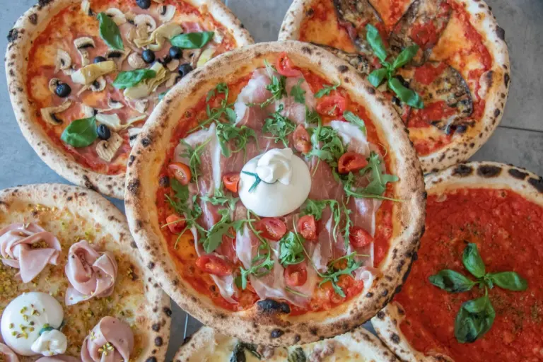 Best pizza restaurant menus in America - Pizza styles comparison: Neapolitan, New York, Chicago deep-dish, Detroit, and tavern pizza on disp
