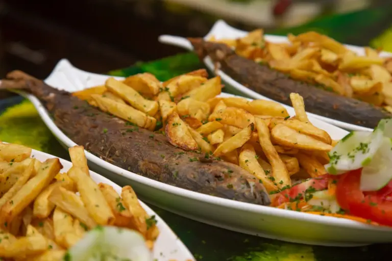 Fish and Chips Explained: Taste, Ingredients, Price, and What to Order With It - Fish and chips served with tartar sauce and lemon wedges on