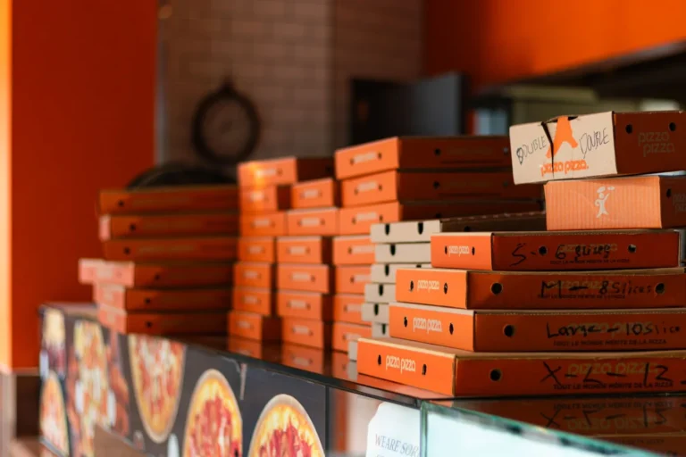 Pizza Hut vs Domino's: Menu Deals, Pizza Styles, and Best Orders - Pizza Hut and Domino's pizza boxes with slices on a table