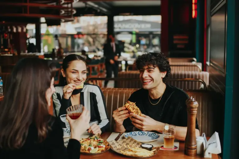Best casual dining menus for groups in America - Group of people sharing appetizers and entrees at a casual dining restaurant table